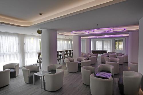 a waiting room with white chairs and a piano at BG Pamplona in Playa de Palma