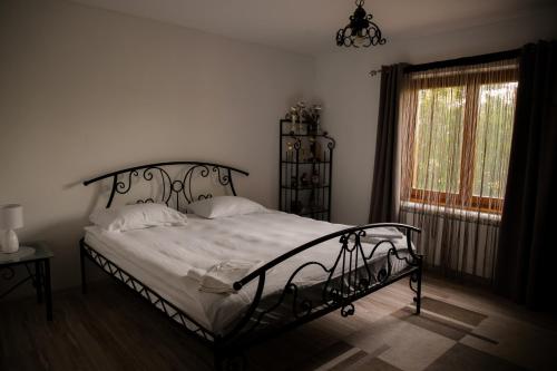 a bedroom with a metal bed in a room with a window at Vila Lio & Restaurant Devojacki Bunar in Novi Vladimirovac
