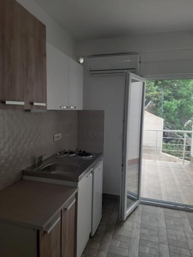 a kitchen with a sink and a sliding glass door at Nino Lux Apartments Ulcinj in Ulcinj