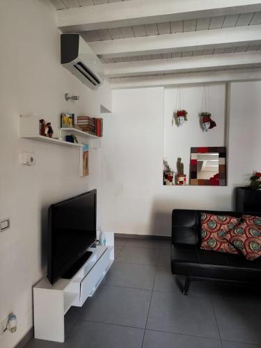 a living room with a black couch and a flat screen tv at House Il Conte in Palermo