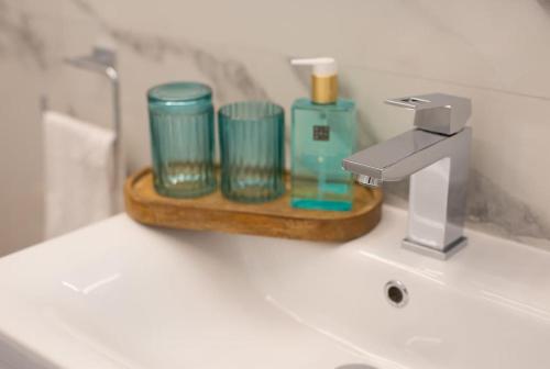 a bathroom sink with a tray with cups and a faucet at Wellness villa Modruna in Grižane