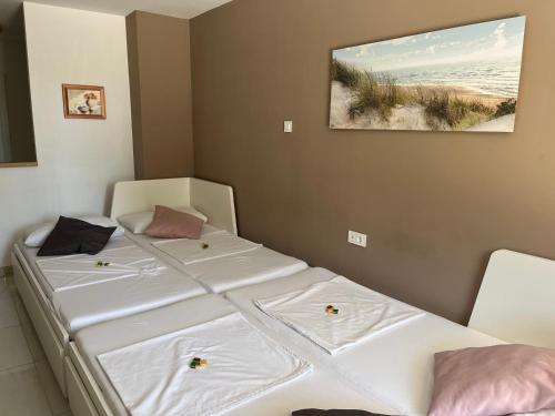 two beds in a room with a picture on the wall at APP Nina Portoroz in Portorož