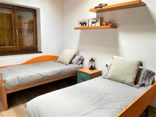 Cette chambre comprend 2 lits et une fenêtre. dans l'établissement Planta baja con jardín en Bor, à Bor