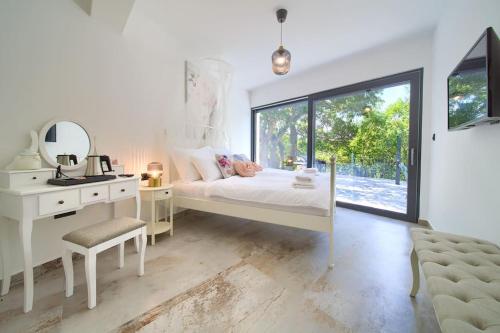 a bedroom with a bed and a desk and a mirror at Wellness villa Modruna in Grižane