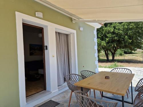 patio con tavolo e sedie in legno e veranda di MemRo Village House a Atsoupádhes