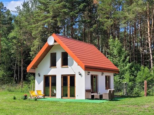 a small house with an orange roof at Kemping i Domki nad stawem in Harsz