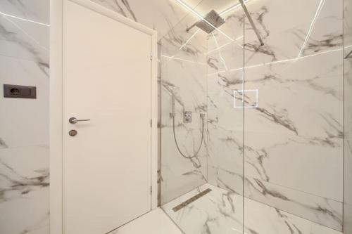 a bathroom with a shower with marble walls at Wellness villa Modruna in Grižane