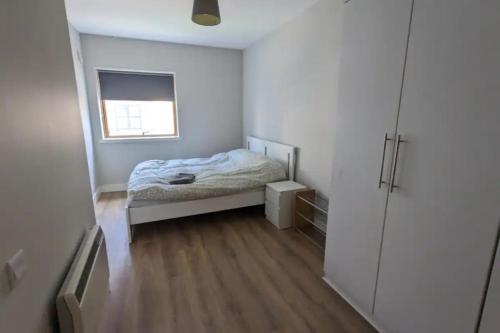 a small bedroom with a bed and a window at Bright 2BD Flat with Private Balcony - Dublin in Dublin