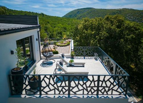 a balcony with a table and chairs on it at Wellness villa Modruna in Grižane