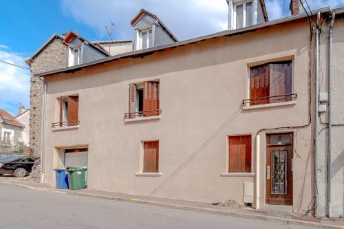 ein weißes Gebäude mit Fenstern auf einer Straße in der Unterkunft Le voyageur de chinchauvaud in Limoges