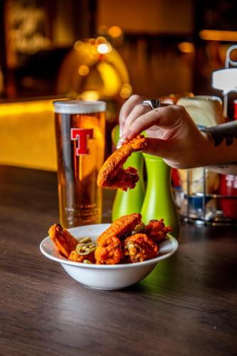 a person is eating a plate of food with a drink at ibis Styles Glasgow Central in Glasgow