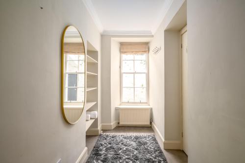 a hallway with a mirror and a rug at Retro New Town Garden Flat in Edinburgh