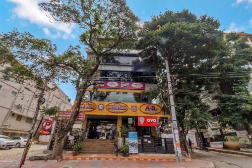a store on a street with trees in front of it at OYO Flagship 81536 Royal Classio in Bangalore