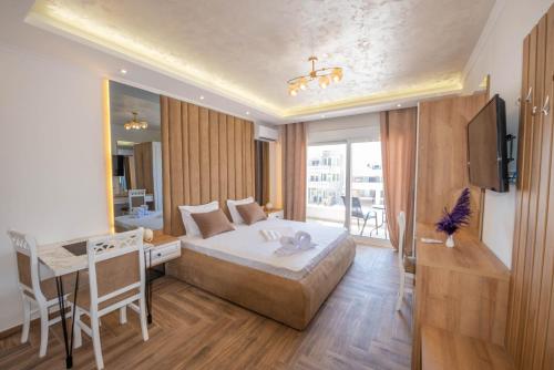 a hotel room with a bed and a desk and a television at Twins Apartment in Ulcinj