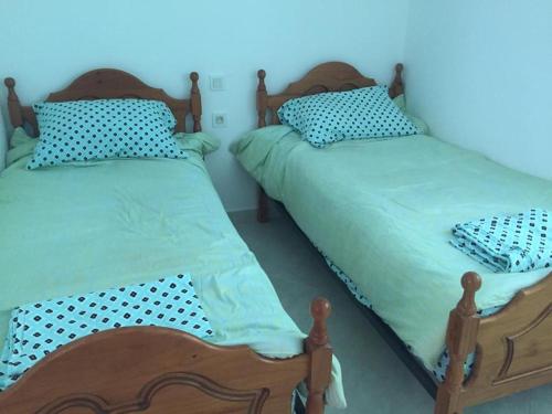 two beds sitting next to each other in a bedroom at Appartement standing in Martil