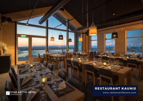 um restaurante com mesas e cadeiras numa sala com janelas em Star Arctic Hotel em Saariselka