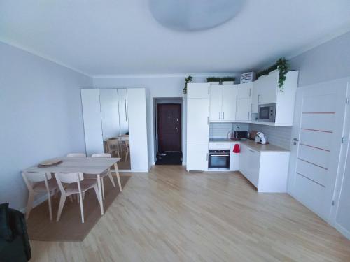 a kitchen with white cabinets and a table and chairs at Great View Studio, self check in, free parking in Klaipėda