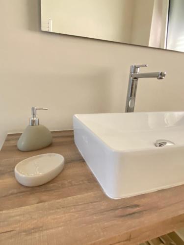 uma casa de banho com um lavatório branco e um espelho. em DONNA PETRONILLA SOUTHERN HOUSE em Pianopoli