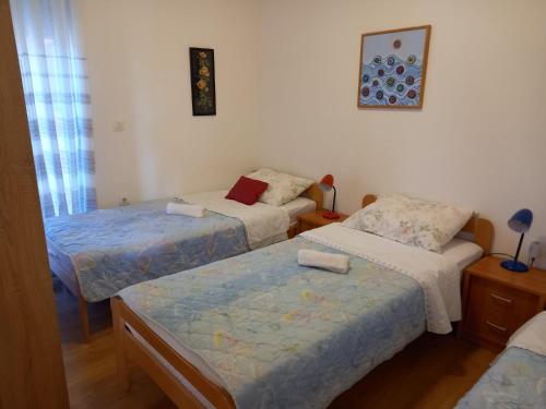 a room with two beds and a bed and a table at Apartment Dragica in Ližnjan