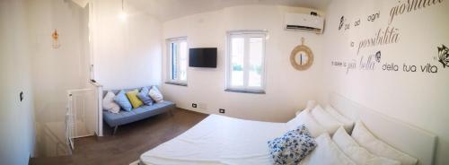 a bedroom with a bed and a couch in it at La Stella Sea House in Torvaianica