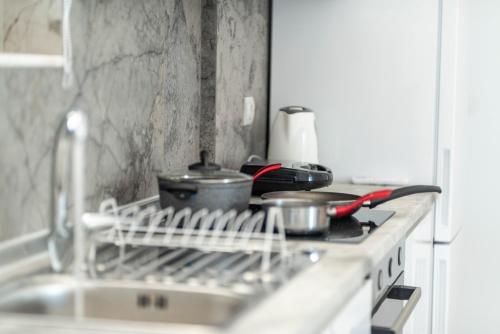 a drying rack on a stove with pots and pans at Diorisa House in Lardos