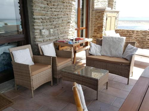 un patio con sillas de mimbre y mesa de centro en Panoramic villa on top of Capo Falcone en Stintino