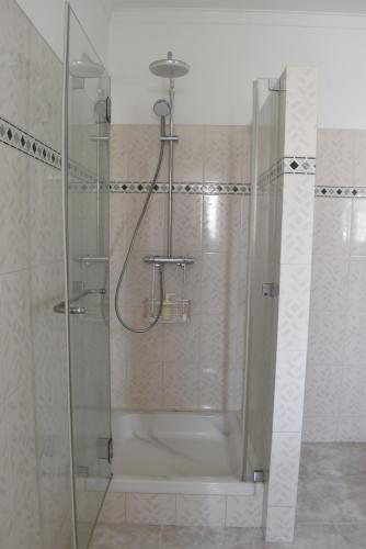 um chuveiro com uma porta de vidro na casa de banho em Ericeira Living na Ericeira