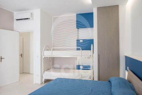 ein Schlafzimmer mit einem Etagenbett in Blau und Weiß in der Unterkunft Villa Odysea - spiaggia a 150m in Torre Lapillo