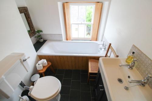 a bathroom with a tub and a toilet and a sink at Sedbergh Cottage, Sedbergh in Sedbergh