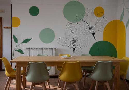 a dining room with a wooden table and yellow chairs at La casetta sotto ai Crivi in Maratea