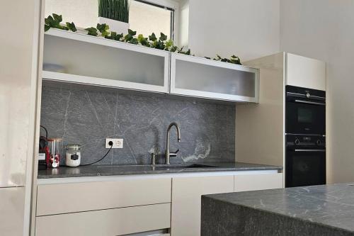 a kitchen with white cabinets and a sink at Best choice für Grazer Kurztripp in Graz