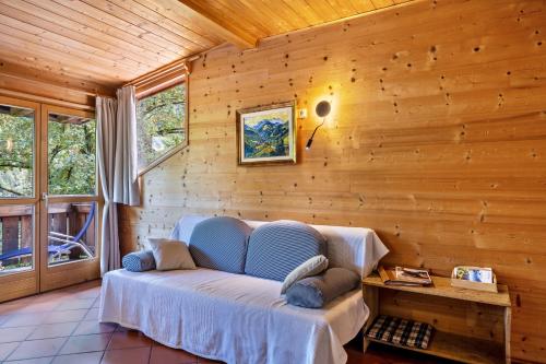 - un salon avec un canapé bleu dans un mur en bois dans l'établissement Mayrhof Apartment Ahorn, à San Pancrazio