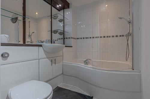 a bathroom with a tub and a toilet and a sink at Amazing Views - 2 Bed - Parking - Central Bham in Birmingham