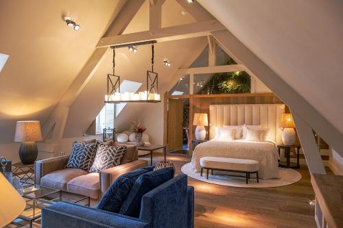 een slaapkamer op zolder met een bed en een bank bij Abbaye du Trésor in Bus-Saint-Rémy