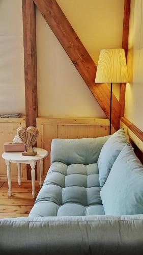 a blue couch in a room with a lamp and a table at I Sicomori - Seme di Carota - Glamping e appartamenti con piscina a Saturnia in Saturnia
