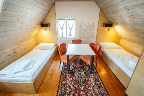 a room with two beds and a table and chairs at HoStel Cosmopolitan* in Banská Štiavnica