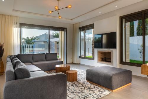 un soggiorno con divano e TV di Houd Taghazout - luxury villa - Pool - 6 or 7 Px a Taghazout