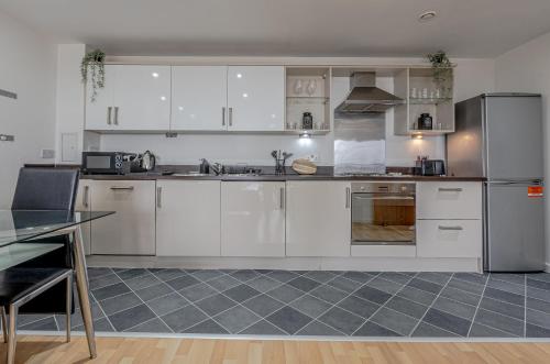 a kitchen with white cabinets and stainless steel appliances at Modern 2BR Apartment City Centre Free Secure Parking Stunning Views in Birmingham