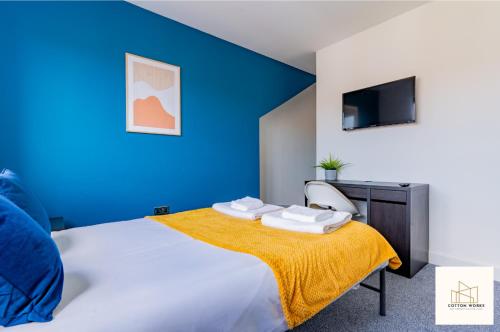 um quarto azul com uma cama com um cobertor amarelo em Monthly Offers, 10 Guests, Business, WIFI em Derby