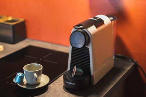 - une machine à café assise sur un comptoir avec une tasse dans l'établissement Studio - Centre La Salle les Alpes Serre Chevalier, à La Salle Les Alpes