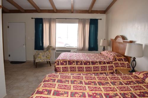 a hotel room with two beds and a window at BUTTERFIELD STAGE MOTEL in Deming