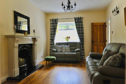 a living room with a couch and a fireplace at Crebilly Cottage - Rural Life doesn't get better in Ballymena