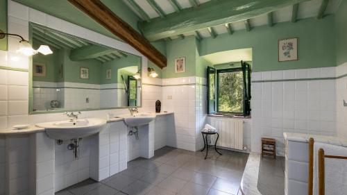 een badkamer met 2 wastafels en een spiegel bij MULINO NEL CHIANTI 10, Emma Villas in Gaiole in Chianti
