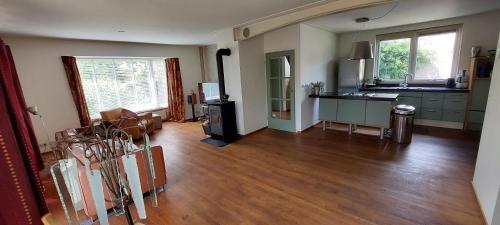 a living room with a wooden floor and a kitchen at Rustig en centraal in Odijk