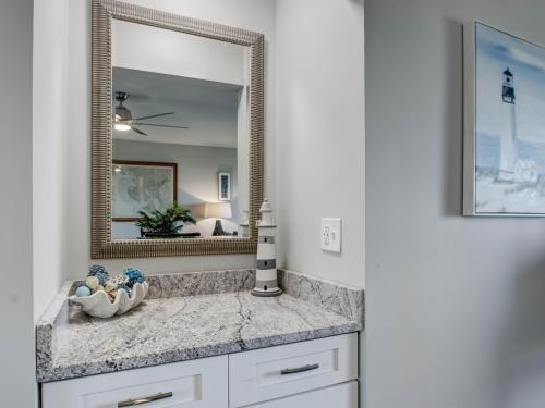 La salle de bains est pourvue d'un lavabo et d'un miroir. dans l'établissement Britt Ohana Place, à Tybee Island