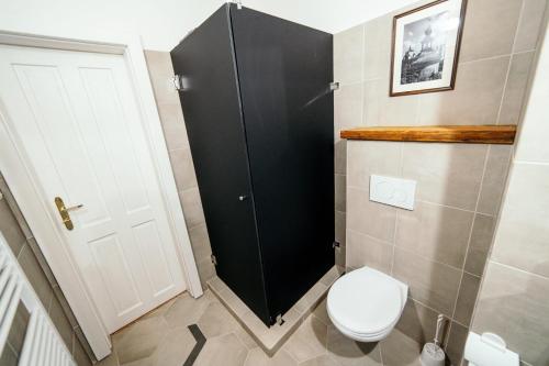 a bathroom with a toilet and a black cabinet at HoStel Cosmopolitan* in Banská Štiavnica