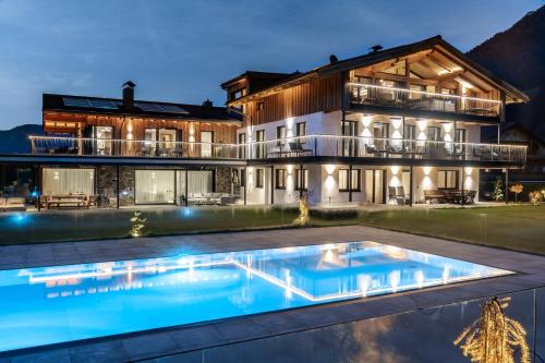 una casa con piscina di fronte a un edificio di Purest ad Achenkirch