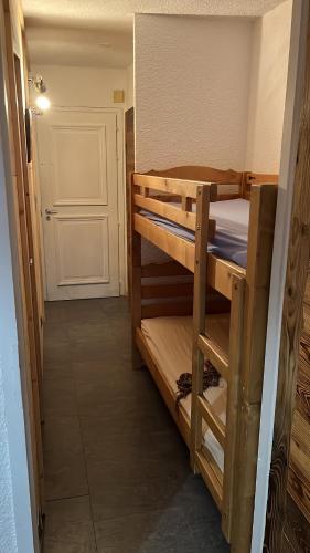 Cette chambre comprend 2 lits superposés et une porte. dans l'établissement Studio avec coin montagne au pied des pistes, à Megève