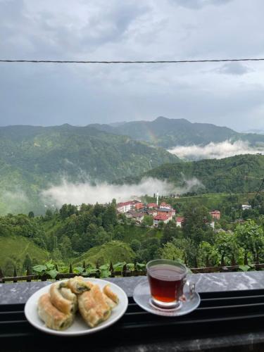 two plates of pastries and a cup of tea on a window at MİNTONA VİLLA SUİT in Çamlıhemşin