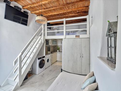 a kitchen with white cabinets and a staircase in a room at Lindo House in Lefkes